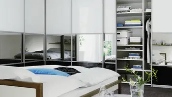 Ein begehbarer Kleiderschrank mit einem Stuhl und verschiedenen Kleidungsstücken.